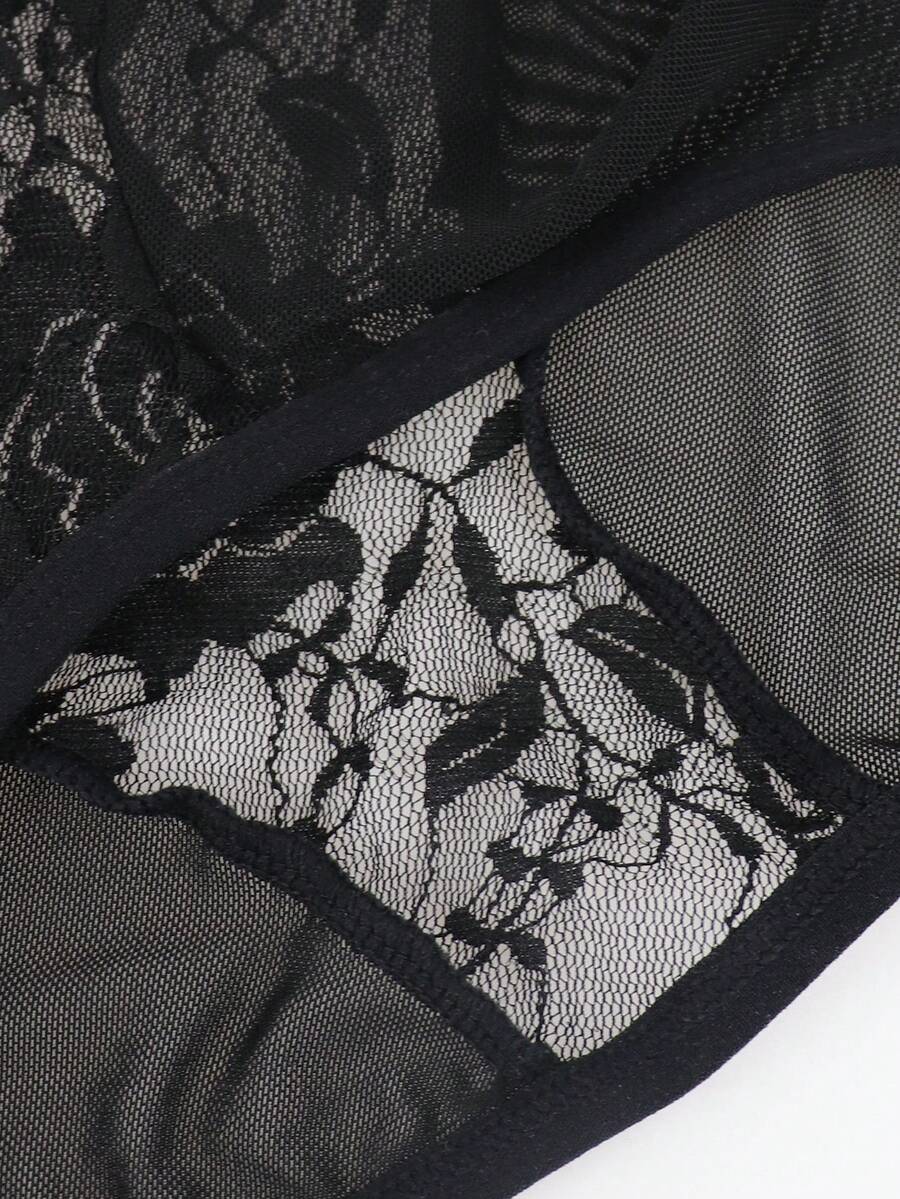 Men's black low rise sheer mesh thong with plant pattern detail.