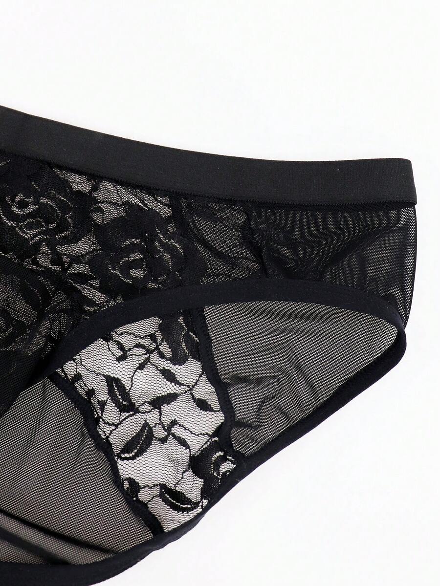 Men's black low rise sheer mesh thong with plant pattern detail.