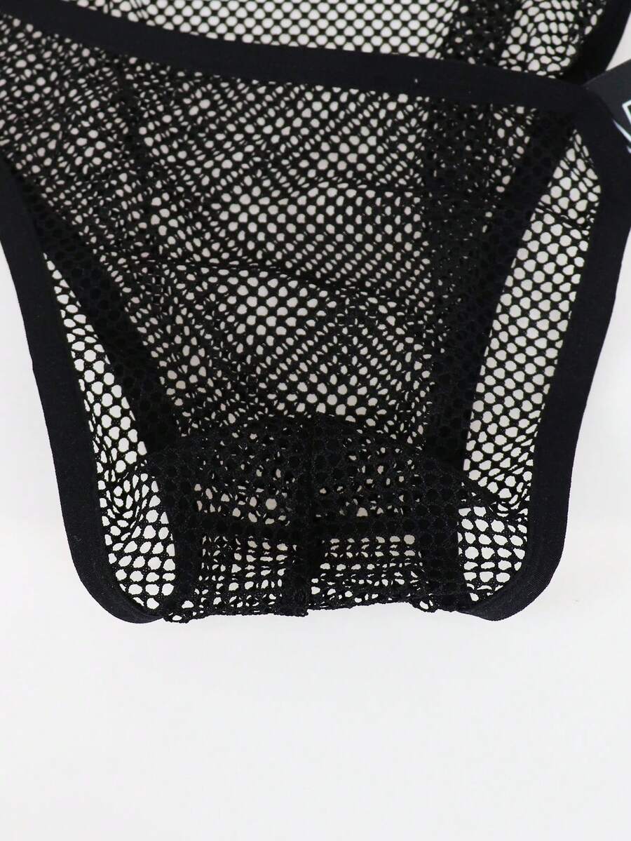 Black men's thong underwear featuring mesh fabric, cut out details, letter pattern, and a low rise fit.