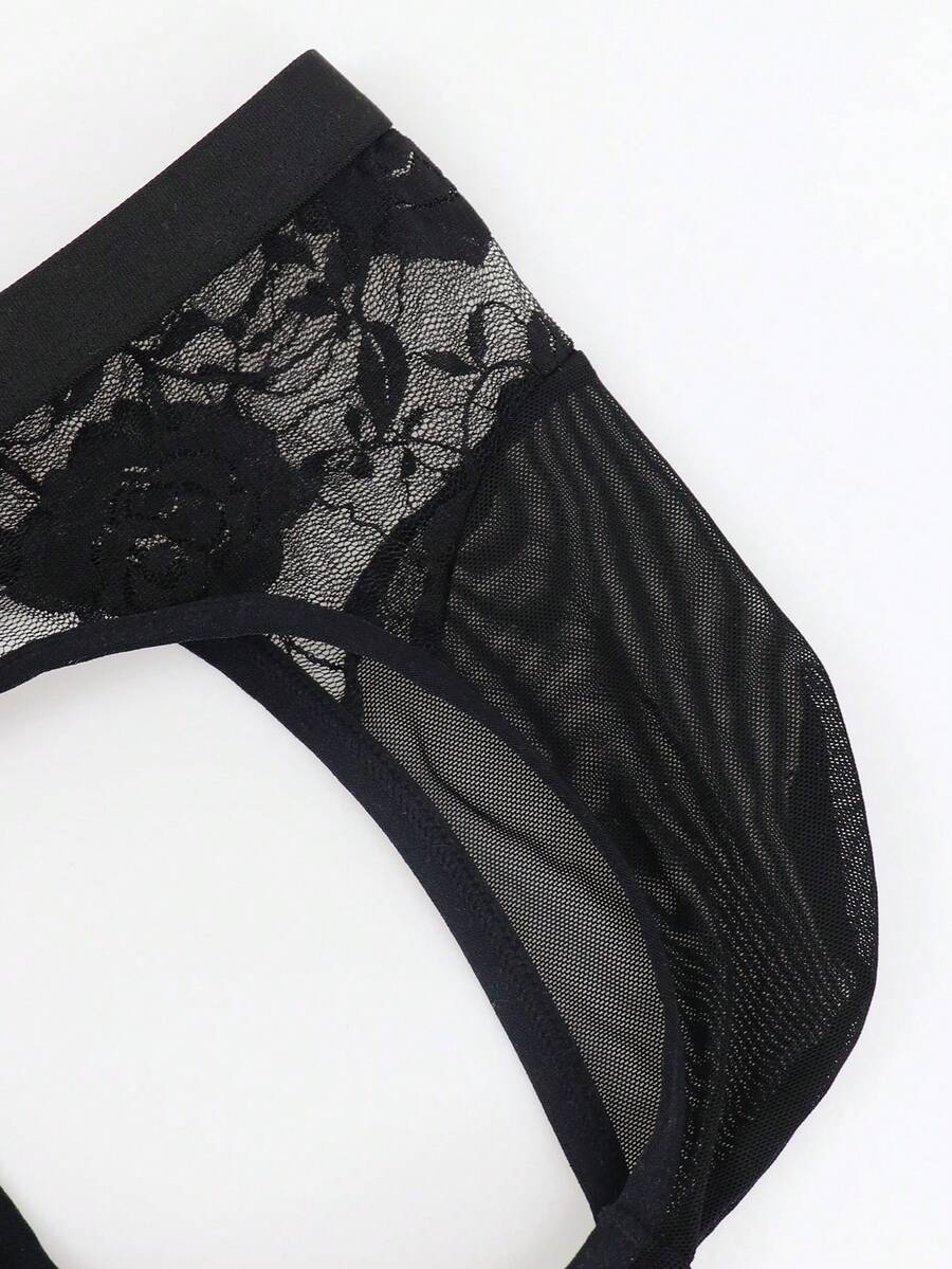 Men's black low rise sheer mesh thong with plant pattern detail.
