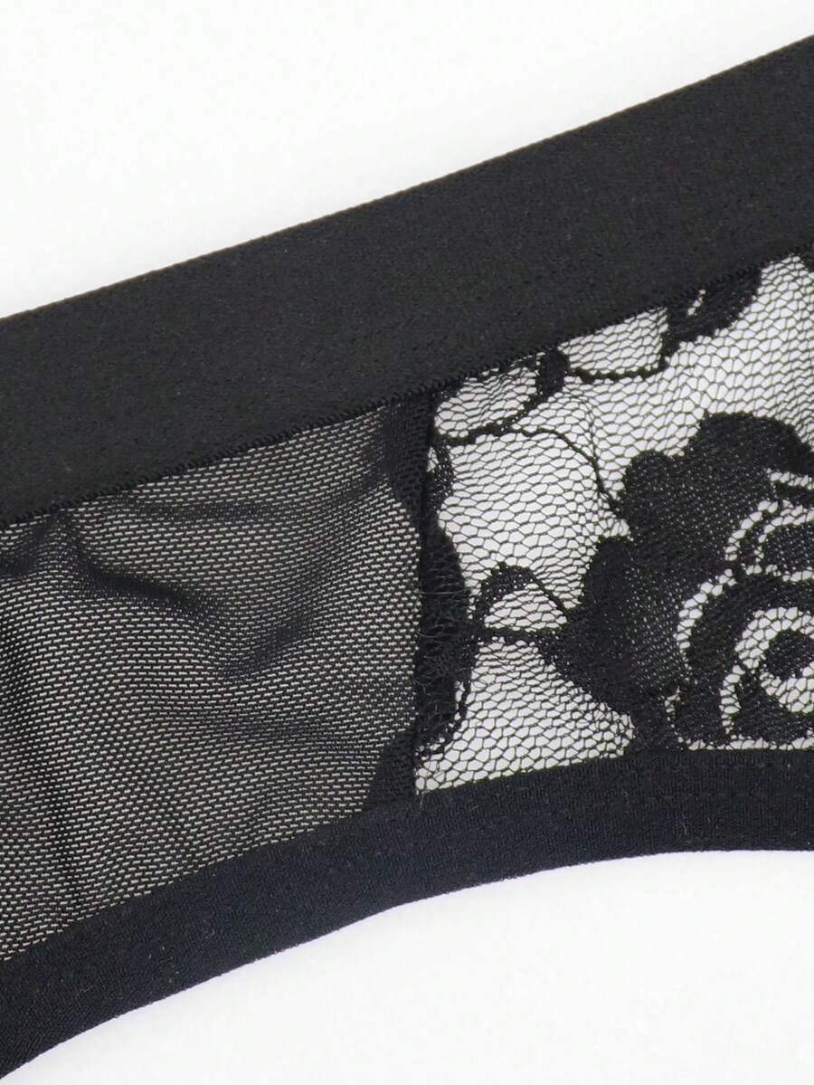 Men's black low rise sheer mesh thong with plant pattern detail.