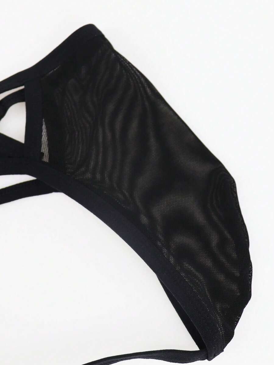 Black men's low rise mesh thong underwear featuring a backless design, sheer fabric, cup detail, and medium stretch material.