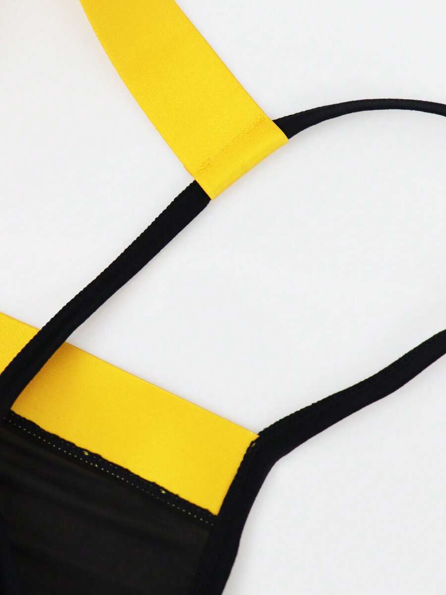 Black low rise men's thong underwear with embroidery detail on knitted fabric.