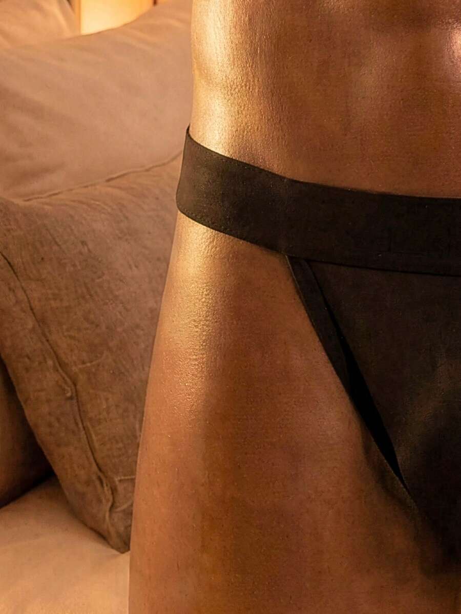 Plain black men's low-rise backless jockstrap underwear featuring a double pouch crafted from stretch knitted fabric.