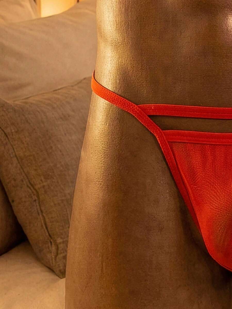 Red low rise men's thong underwear made from colorblock mesh fabric.