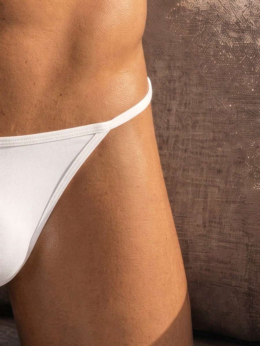 Men's black knitted fabric low-rise thong underwear featuring knot detail.