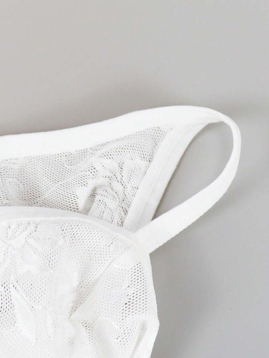 White lace thong underwear for men featuring a low rise waist and plant pattern knitted fabric.