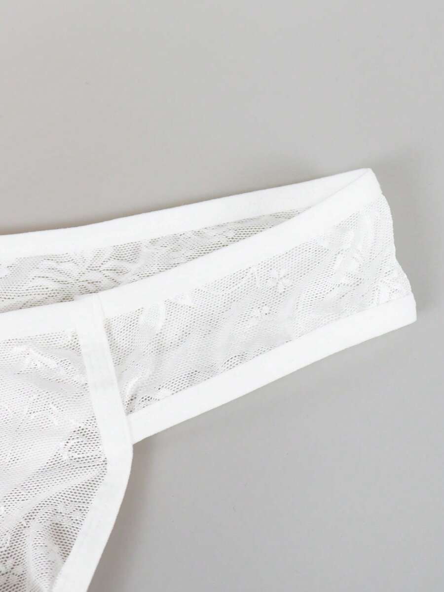 White lace thong underwear for men featuring a low rise waist and plant pattern knitted fabric.
