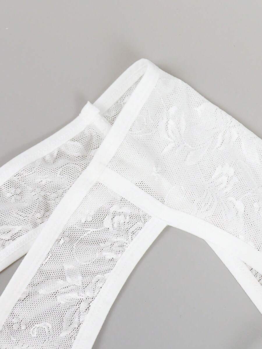White lace thong underwear for men featuring a low rise waist and plant pattern knitted fabric.