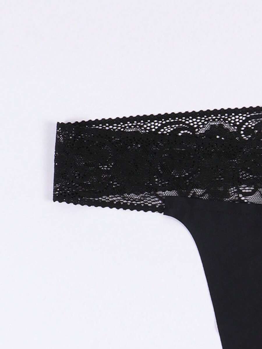 Black men's low rise thong underwear featuring a letter printed waistband and tape details.