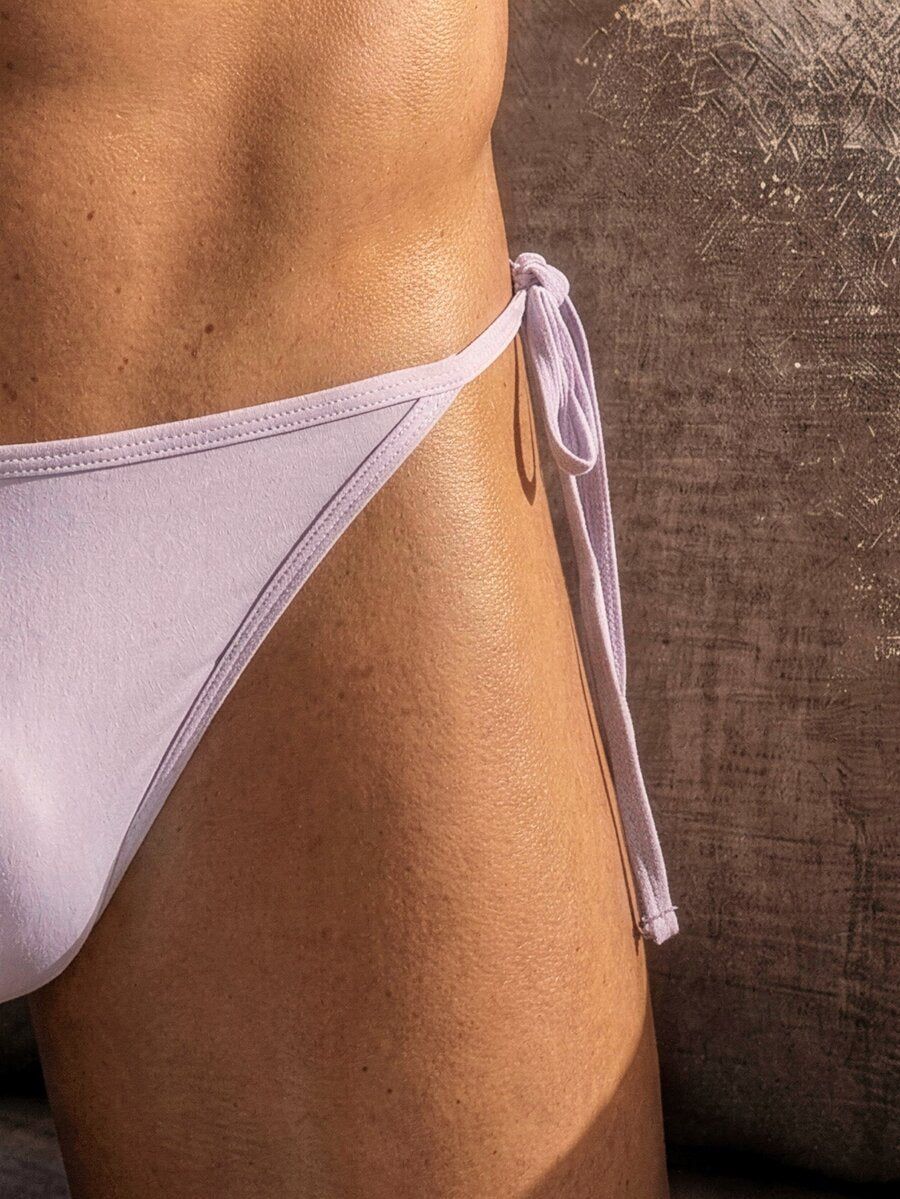 Men's black knitted fabric low-rise thong underwear featuring knot detail.