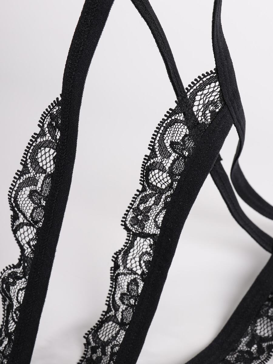 Men's black low-rise lace trim thong underwear featuring ring details and medium stretch knitted fabric.