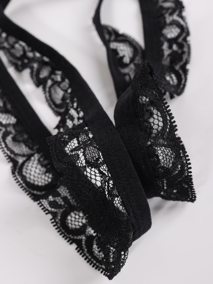 Men's black low-rise lace trim thong underwear featuring ring details and medium stretch knitted fabric.
