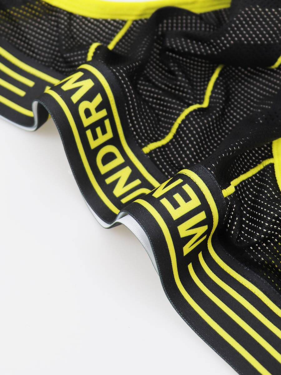 Black mid-rise men's jockstrap underwear featuring bold yellow trim and patterned waistband.