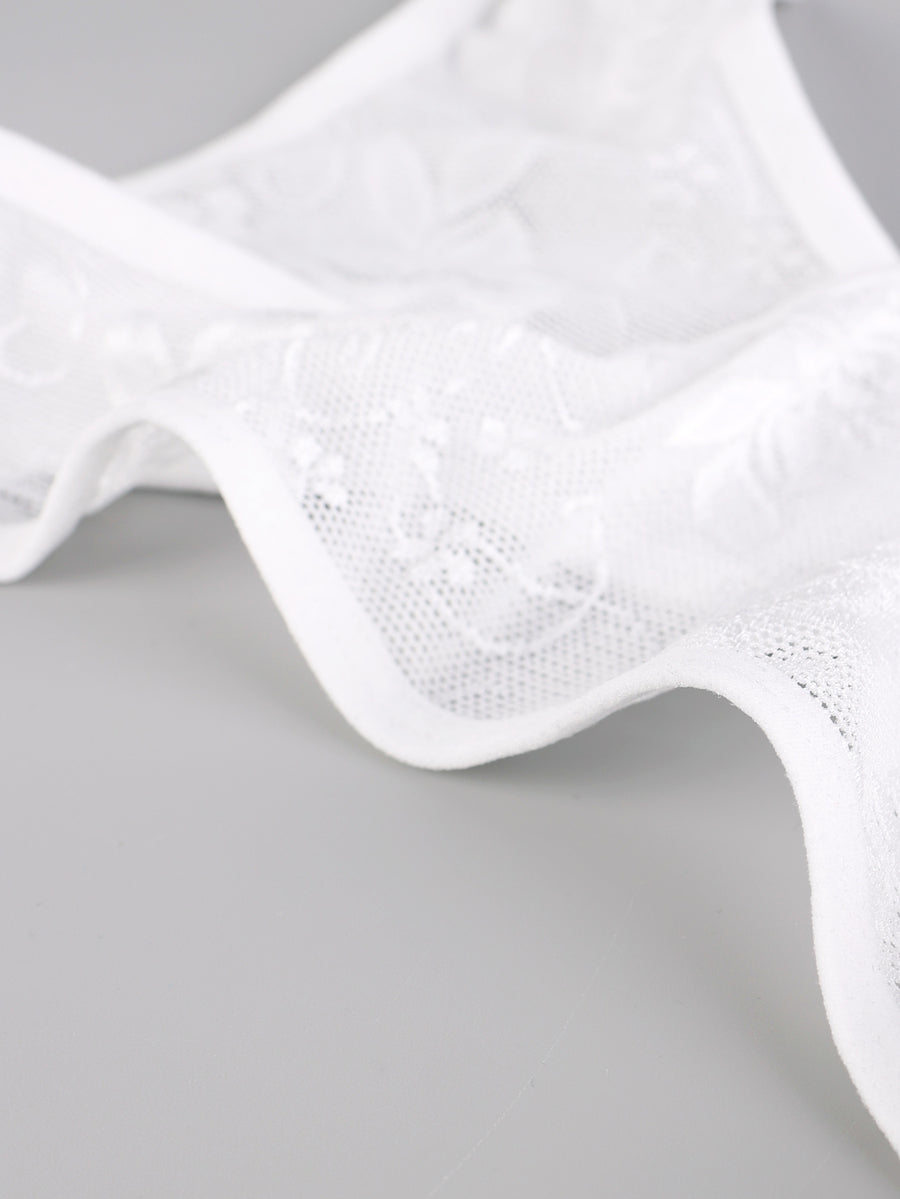 Men's white lace thong bodysuit with a low rise waist in medium stretch knitted fabric.