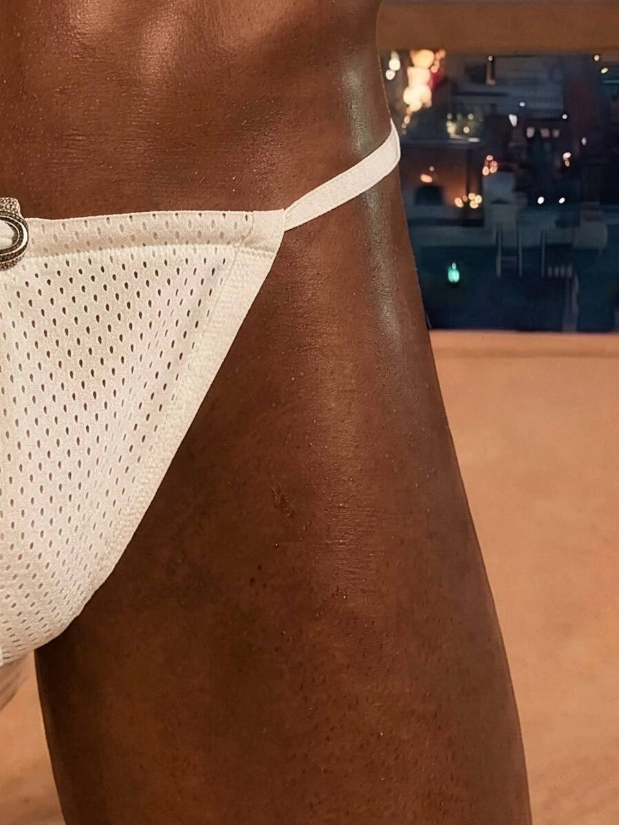 White men's low rise V-string thong underwear made of knitted polyester stretch fabric.